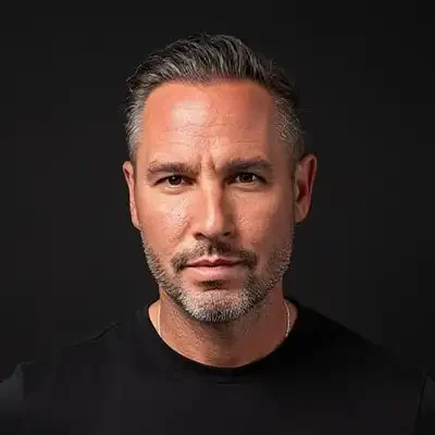 Chiropractor Shallotte NC Brian Lank headshot with short gray hair and a neatly trimmed beard, wearing a black shirt and facing the camera